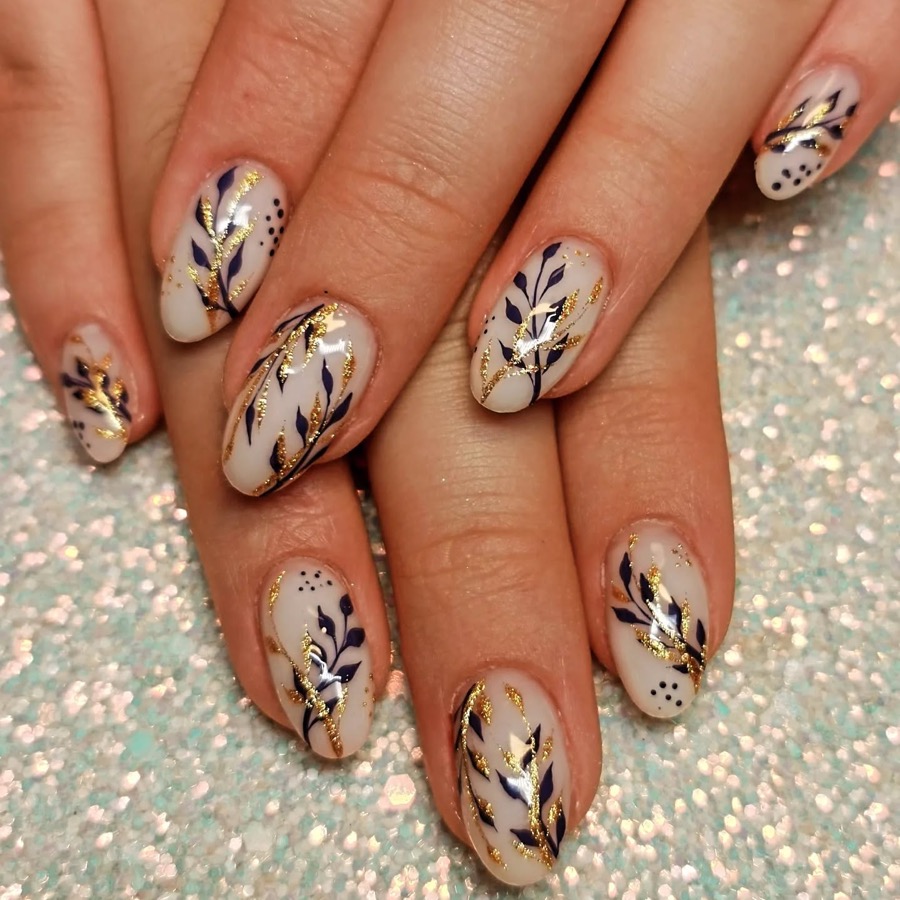 Ongles nude décorés de feuillage bleu marine et doré